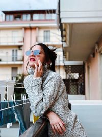 Young woman sitting on table against built structure