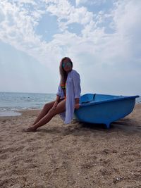 Portrait of woman on beach against sky
