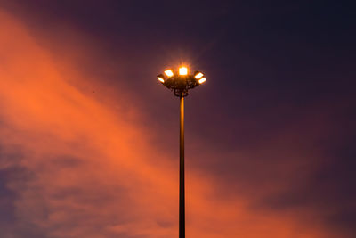 Low angle view of illuminated street light against sky at sunset