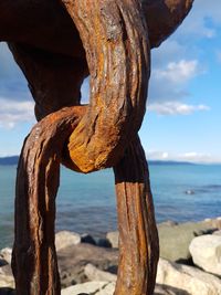 Close-up of wooden post in sea against sky