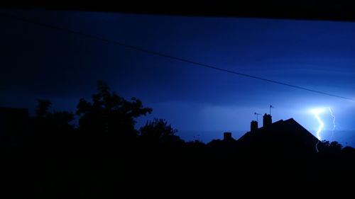 Low angle view of silhouette trees against sky at night
