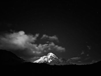 Scenic view of snowcapped mountains against sky at night