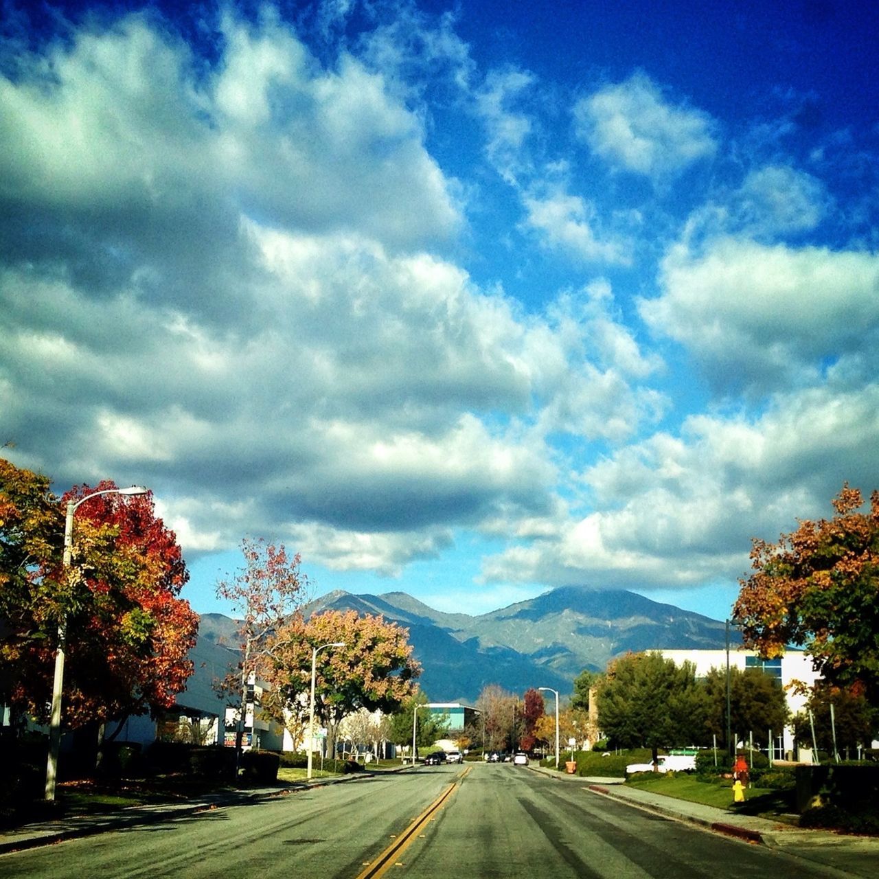 sky, cloud - sky, the way forward, road, transportation, cloudy, cloud, tree, diminishing perspective, mountain, car, vanishing point, street, country road, road marking, weather, storm cloud, nature, empty, scenics