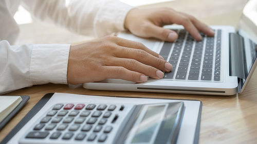 Midsection of man using laptop on table