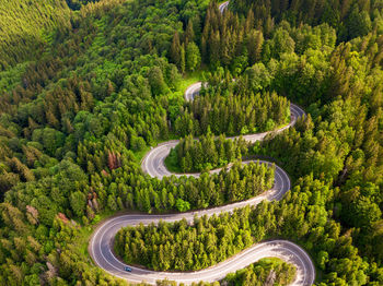 Winding road from high mountain pass, in summer time. aerial view by drone . romania