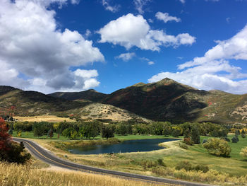 Scenic view of road by mountains against sky
