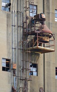 Low angle view of rusty grain elevator on building