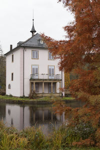 Building by river against sky