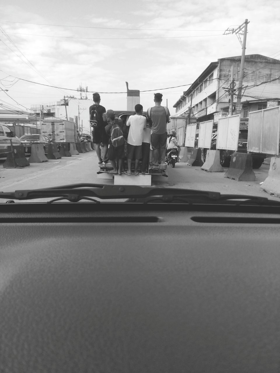 REAR VIEW OF MEN ON ROAD IN CITY