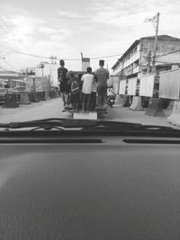 Rear view of people on road in city