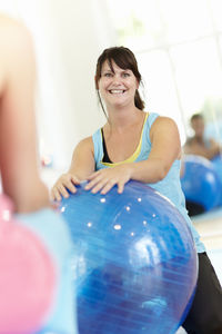 Smiling woman with fitness ball