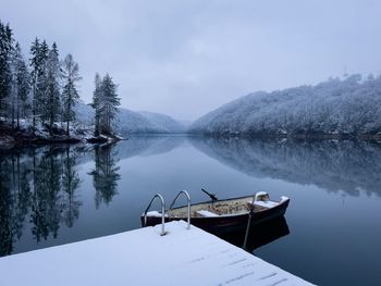 Boat on the lake in winter and trees covered in snow