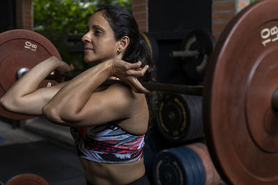 Young woman exercising dumbbell in gym