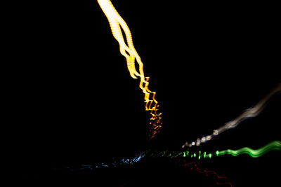 Close-up of illuminated lighting equipment against black background