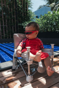 Side view of boy using mobile phone while sitting on table