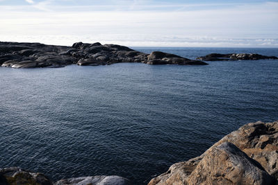 High angle view of sea against cloudy sky during sunny day