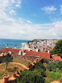 High angle view of townscape by sea against sky