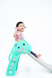 Portrait of boy playing with toys against white background
