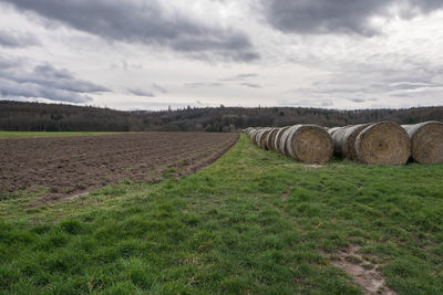 Hay bales on field against sky