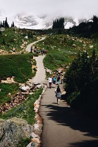 People walking on landscape against sky