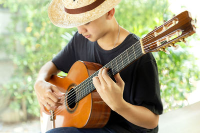 Low section of man playing guitar