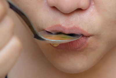 Cropped image of woman having soup with spoon