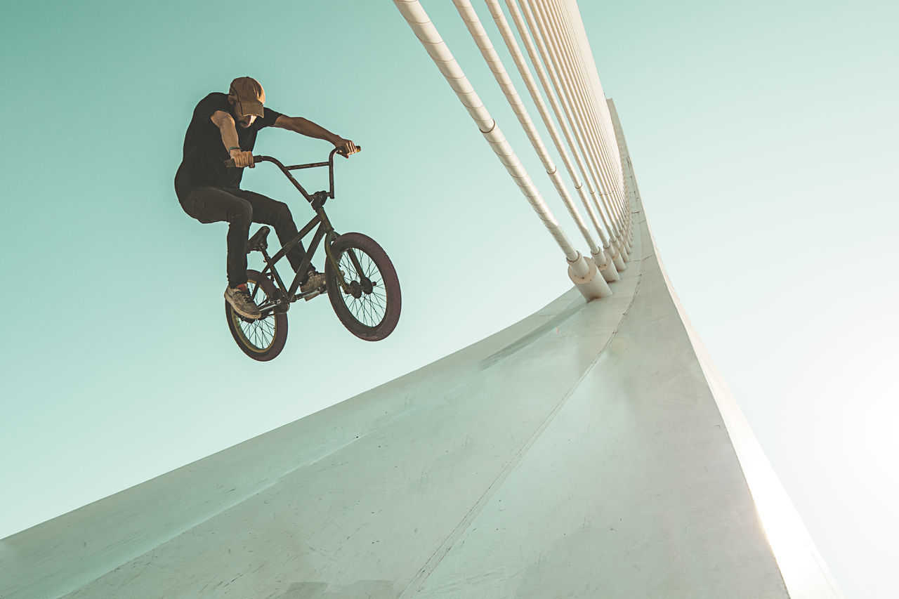 LOW ANGLE VIEW OF MAN RIDING BICYCLE