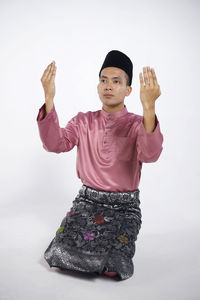 Portrait of man standing against white background