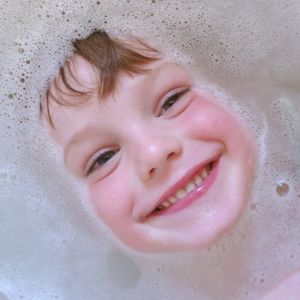 Directly above portrait of smiling boy in bathtub