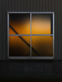 Close-up of yellow wall by window at night