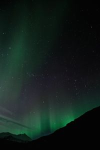 Low angle view of silhouette mountain against sky at night