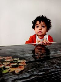 Portrait of cute boy against wall