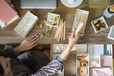 Directly above shot of woman sitting by personal accessories at home