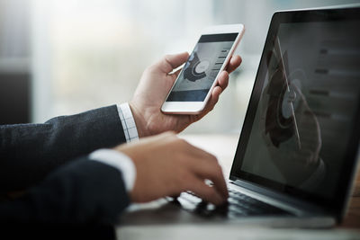 Midsection of businessman using mobile phone