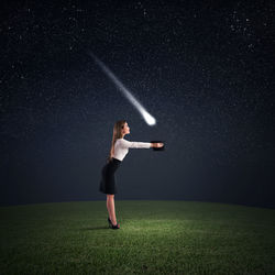 Full length of woman standing on field against sky at night