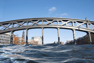 Bridge over sea against clear blue sky