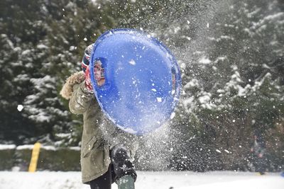 Boy playing on snow covered field