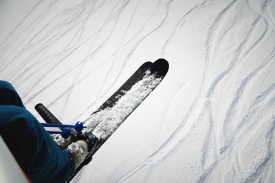 A skier sits on a chair lift on a beautiful day, alpine mountains. skiing concept. side view of a