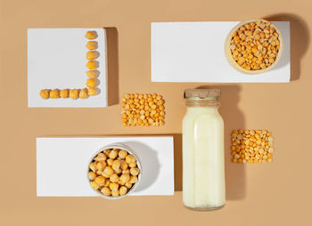 Pea milk in a bottle,chickpeas on white podium.gluten,lactose free vegan product. flat lay.top view