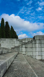 View of footpath against cloudy sky