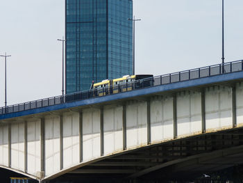 Low angle view of bridge against buildings in city