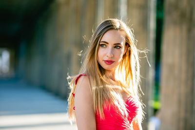 Woman wearing red dress while standing in corridor