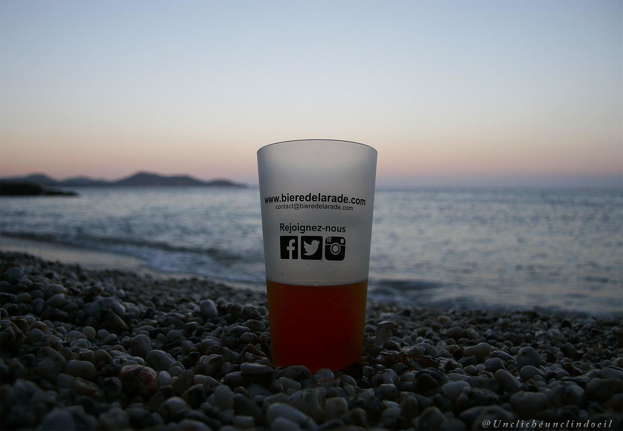 CLOSE-UP OF TEXT ON PEBBLES AT SUNSET