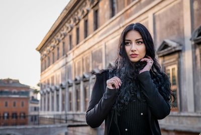 Portrait of a beautiful young woman standing outdoors