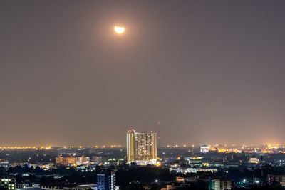 Illuminated buildings against sky at night