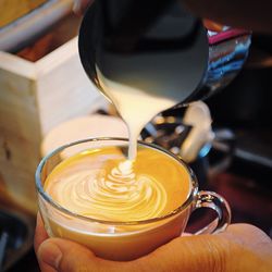 Cropped hands preparing coffee in cafe