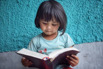 Cute girl sitting on book