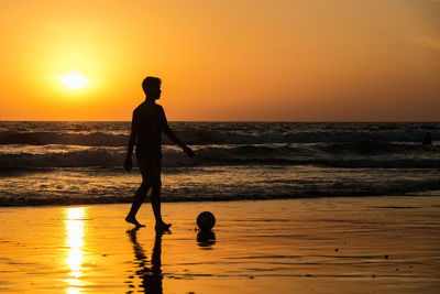 Silhouette man standing on beach against sky during sunset. seminyak bali