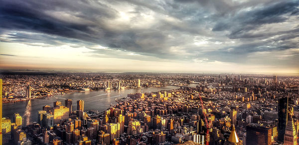 High angle view of city buildings against cloudy sky