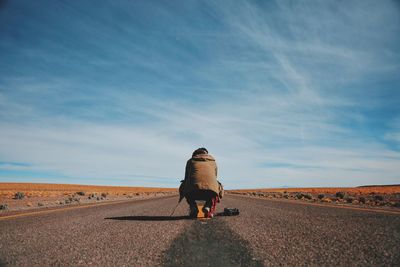 Rear view of person sitting on road